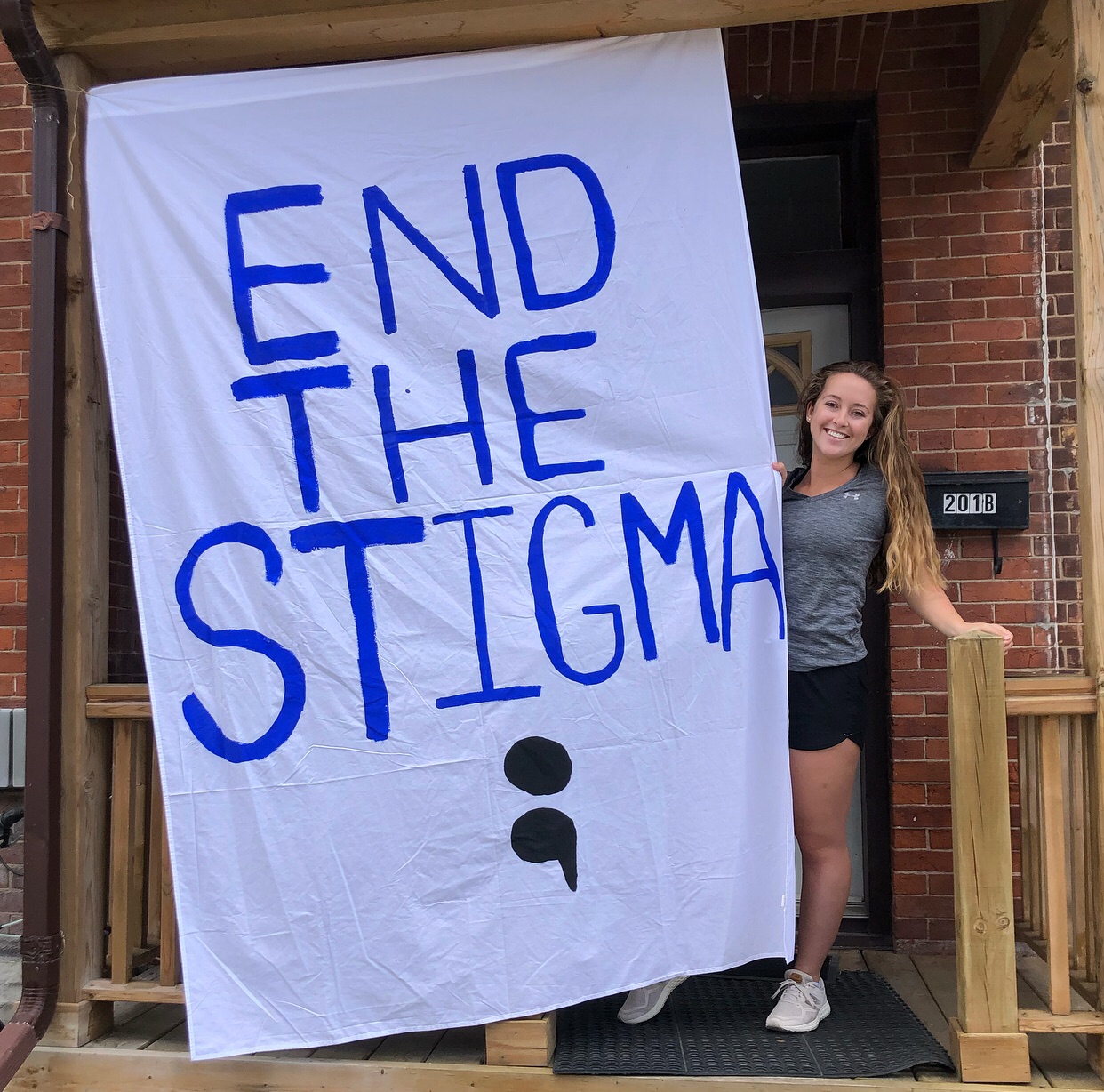 Woman with flag saying "End the Stigma"